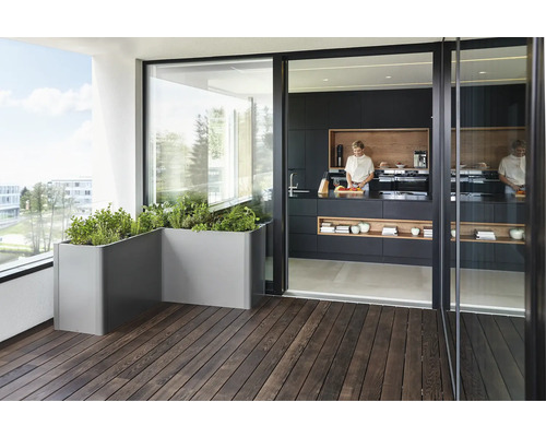 Balkong med planteringslådor och kök med matlagningsperson