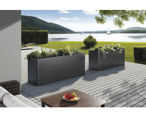 Två blomlådor på en terrass med utsikt över en sjö.