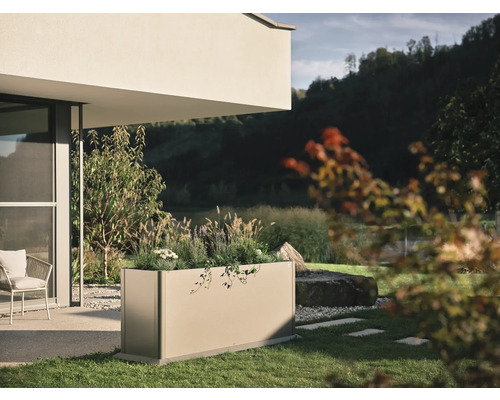 Rektangulär metallplanteringslåda med växter i trädgården