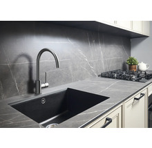 Köksscen med diskho, blandare och spishäll på bänkskiva