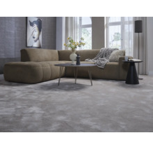 Vardagsrum med hörnsoffa, matta, bord och golvlampa