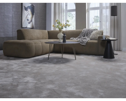 Vardagsrum med hörnsoffa, matta, bord och golvlampa