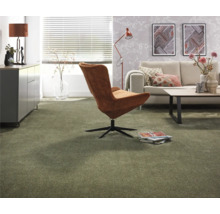 Vardagsrum med heltäckningsmatta, fåtölj, soffa och sidobord