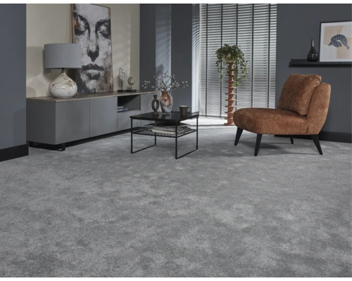 Vardagsrum med grå matta, brun fåtölj, TV-skåp och soffbord