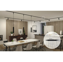 Interiör med matbord, köksö och svart strömskena med spotlights och pendellampor.
