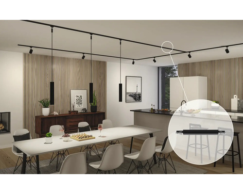 Interiör med matbord, köksö och svart strömskena med spotlights och pendellampor.