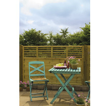 Trädgårdsscen med trästaket, bord och stol