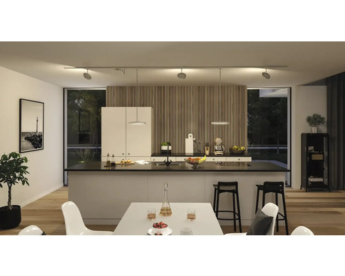 Modernt kök med köksö, matbord och flexibel skenmonterad belysning.