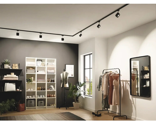 Klädkammare med hyllor, klädställning, spegel och svart skensystem med spotlights