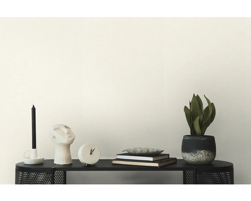 Dekoration med ljus, skulptur, klocka, böcker och krukväxt på en svart hylla