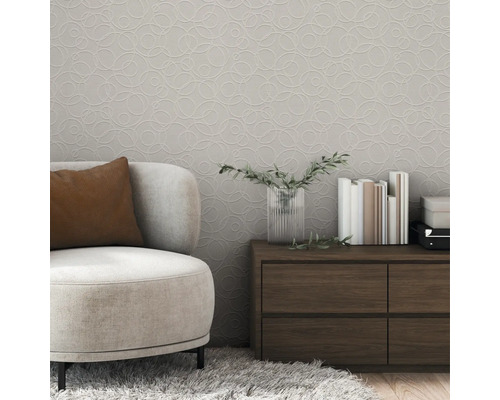 Vardagsrum med beige fåtölj, träbord och mönstrad tapet