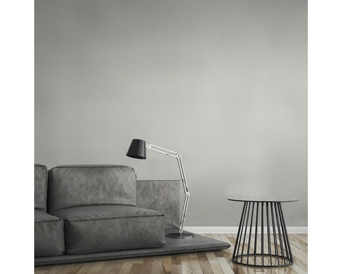 Grå soffgrupp med golvlampa och sidobord mot en strukturerad vägg