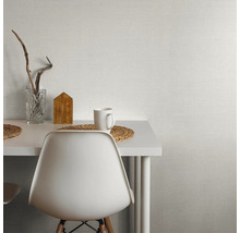 Ljust vardagsrum med bord, stol, dekoration och ljus tapet