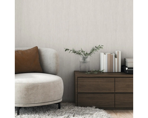 Vardagsrum med fåtölj, byrå, böcker och vas