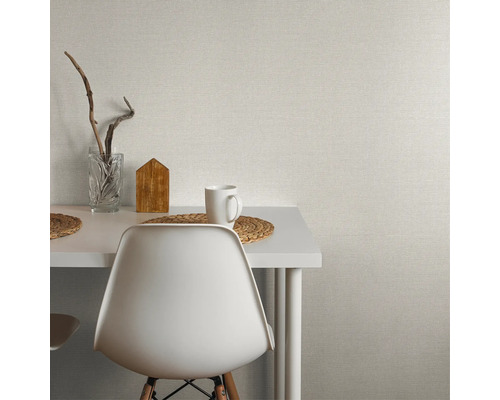 Ljust vardagsrum med enfärgad tapet, bord och stol