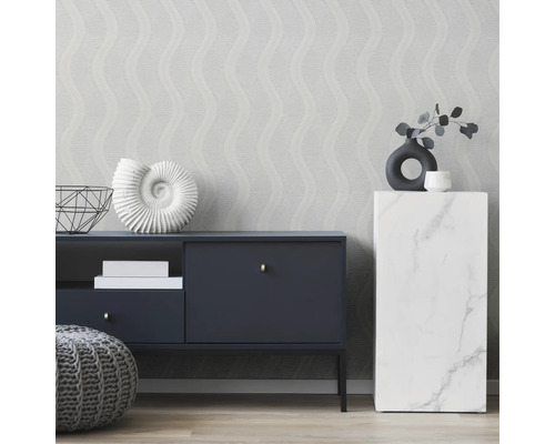 Dekorativt vardagsrum med byrå, marmorpelare och mönstrad tapet