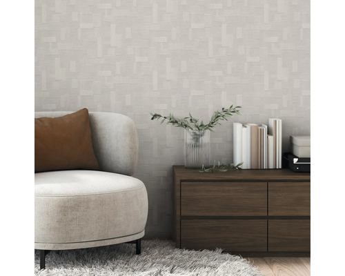 Miljöbild med en fåtölj, ett skåp och en geometrisk tapet.