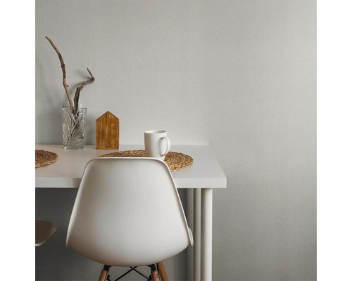 Scen med vitt bord, stol, mugg, trädekoration och glasvas.