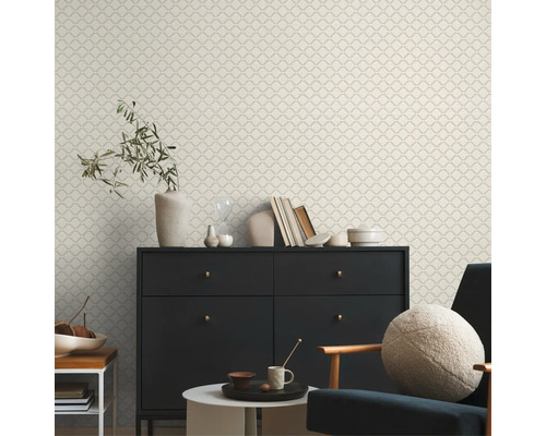 Dekorativt vardagsrum med mönstrad tapet, byrå och stol