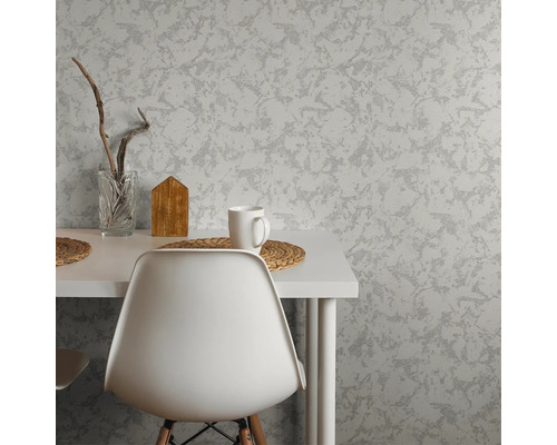 Vardagsrum med mönstrad tapet, bord och stol