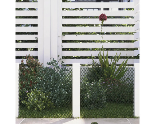 Synskyddsnät framför växter och ett vitt staket