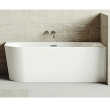 Fristående badkar av sanitetsakryl med armaturer på väggen.