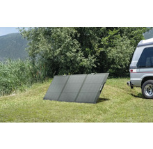 Bärbar solpanel på en gräsmatta bredvid en husbil