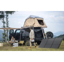 Campingplats med bil, taktält, solpaneler och människor som deltar i utomhusaktiviteter