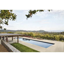 Landskapsvy med pool, solstolar och paviljong