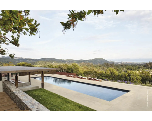 Landskapsvy med pool, solstolar och paviljong