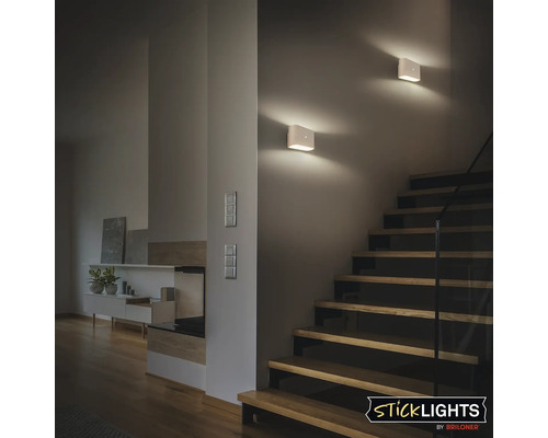 Trapphus med två fyrkantiga vägglampor och trappa