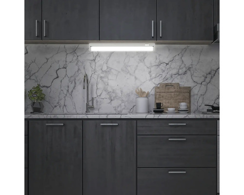 Köksscen med underskåpsbelysning, diskho och redskap