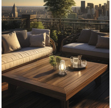 Terrass med loungemöbler och träbord med stadsbild i bakgrunden