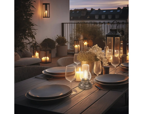 Dukat bord på en terrass med lampor och dekorationer för en trevlig atmosfär