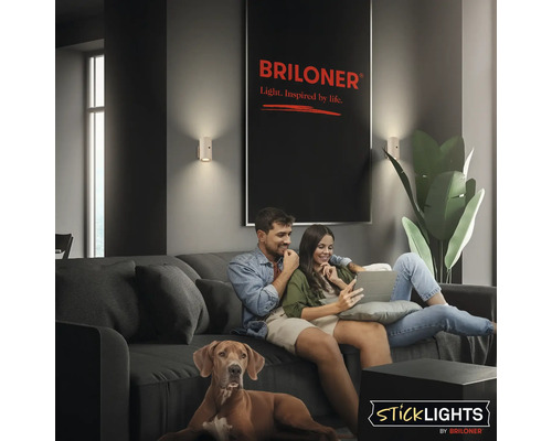 Vardagsrum med par i soffan, hund och vägglampor