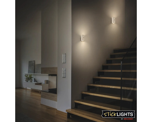 Scen med två vägglampor i ett trapphus som lyser upp en trappa