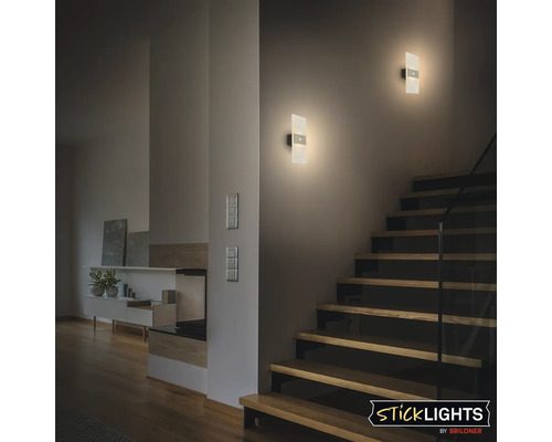 Hall med trappa och två upplysta vägglampor