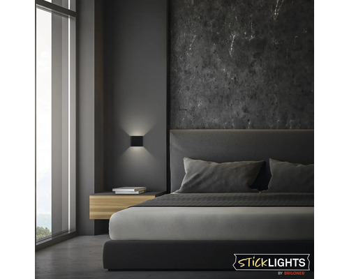 Sovrum med dubbelsäng, sängbord, vägglampa och fönster