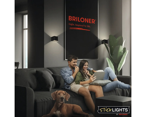 Vardagsrum med par i soffan, hund och Briloner vägglampor