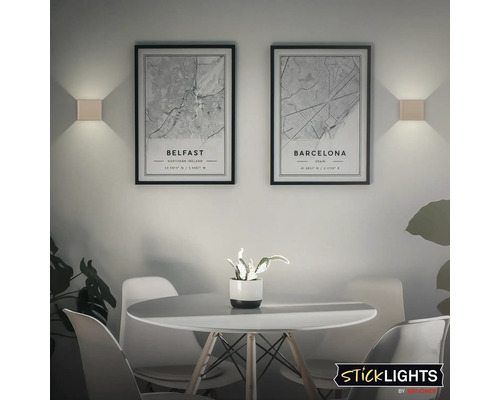 Vardagsrum med matbord, stolar och vägglampor