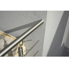Rostfritt stålräcke fäst på en vägg.