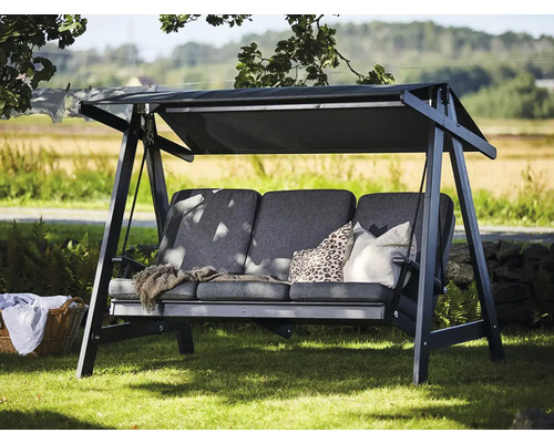 Trädgårdsgunga med tak och kuddar på gräsmatta