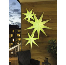 Dekorativa pappersstjärnor hänger på en trävägg på en balkong.