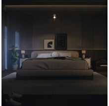 Sovrum med säng, sängbord och dekorativa element för en avkopplande atmosfär