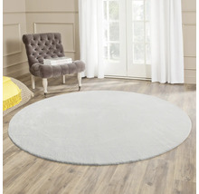 Rund matta i vardagsrum med fåtölj och dagsljus.