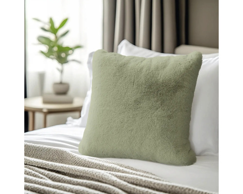 Prydnadskudde i fuskpäls på en säng