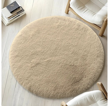 Rund, beige matta på ljust trägolv, omgiven av stolar och böcker.