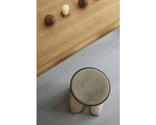 Toppvy av en rund pall med pälsöverdrag och ett träbord med dekoration