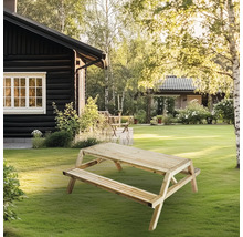 Picknickbord i trä i trädgården framför huset