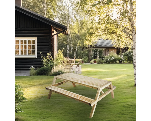 Picknickbord i trä i trädgården framför huset